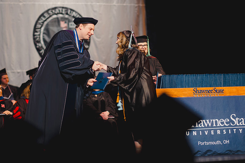 SSU President Eric Braun handing out diplomas during the Fall 2023 Commencement Ceremony