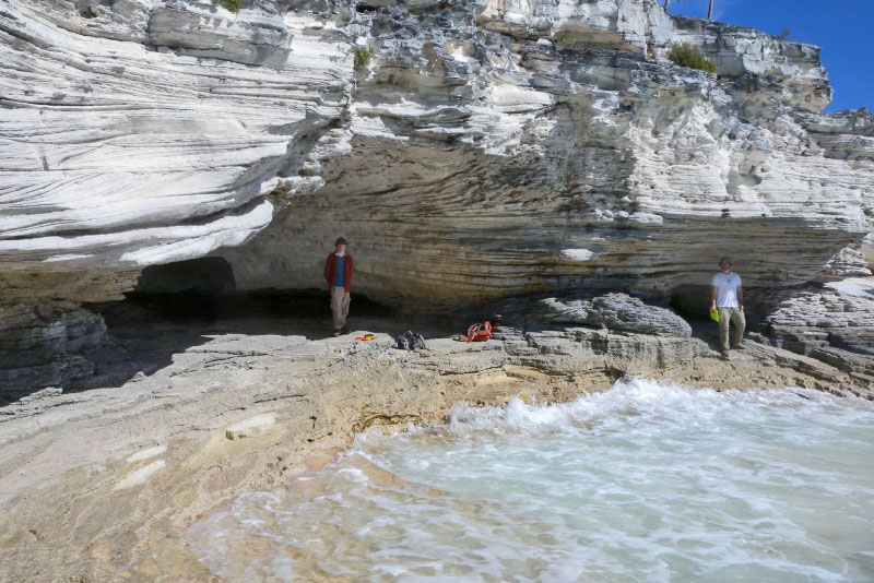 2 people by rock formation by water 2 people by rock formation by water