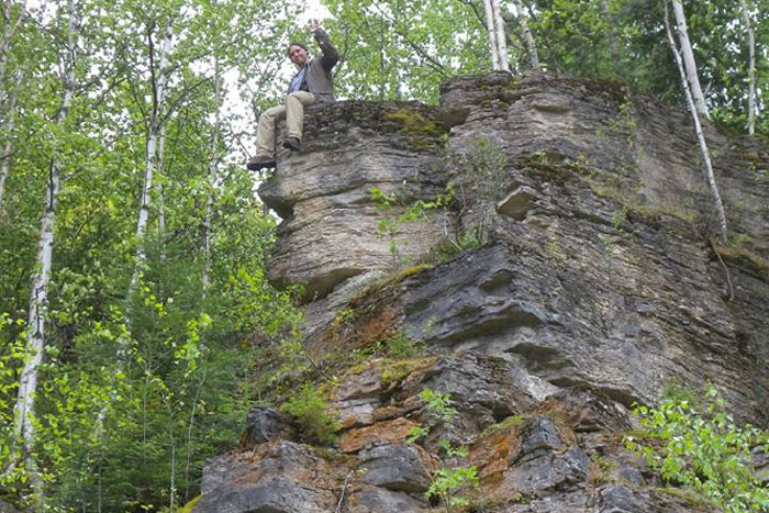person sitting on large rock formation person sitting on large rock formation