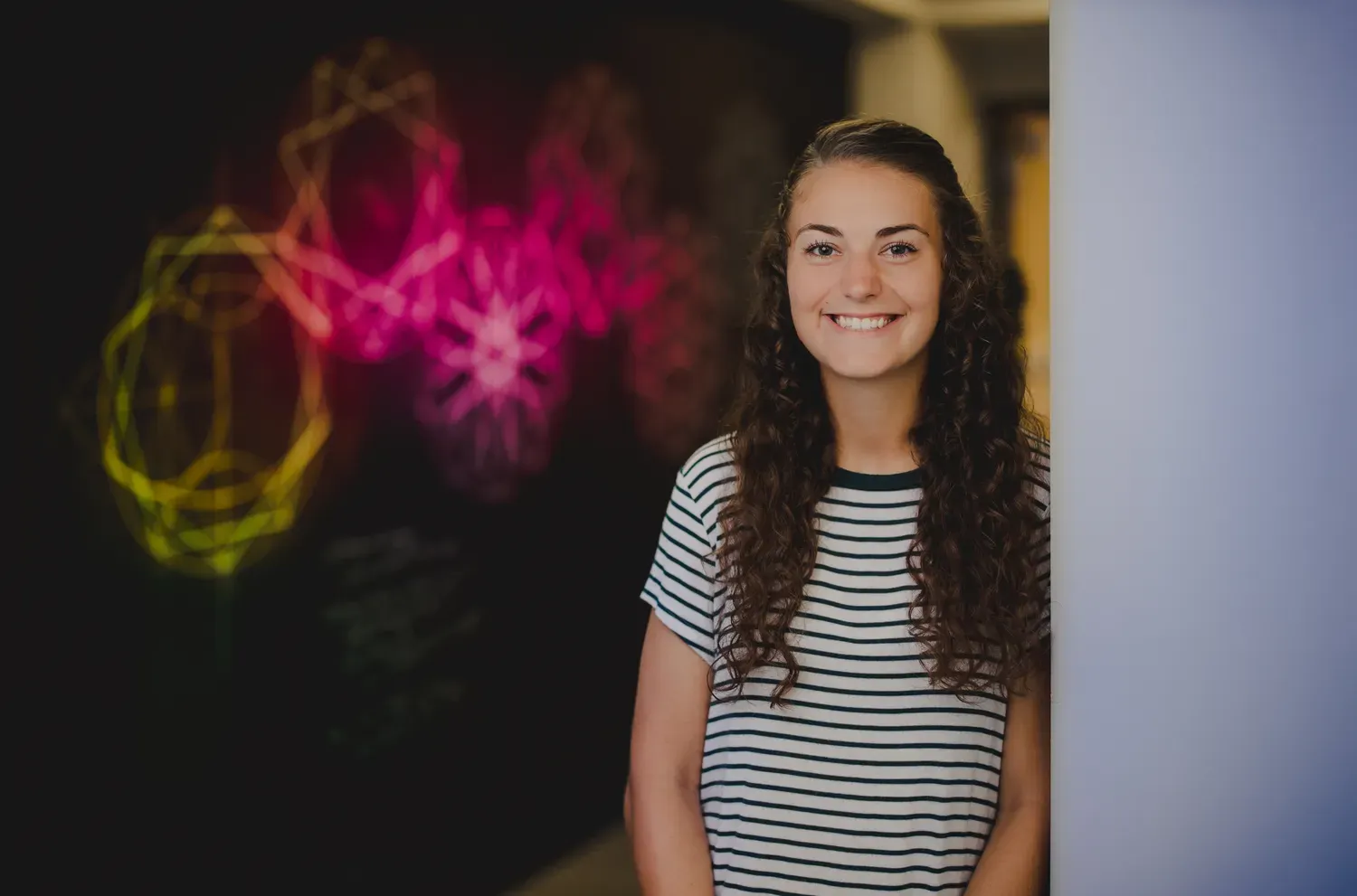 Student standing and smiling in the hallway