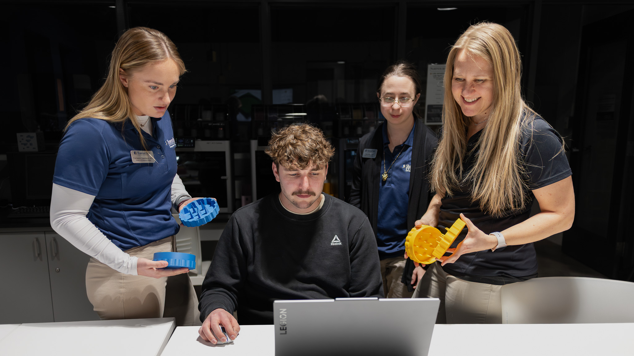 Students in plastics engineering lab collaborating on 3D printed project.