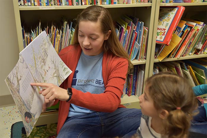 woman reading to young students