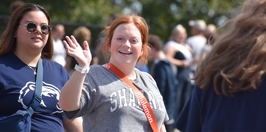 student waving in parade