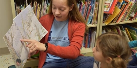 woman reading to young students