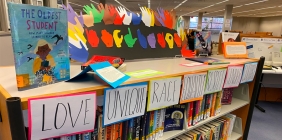 books and signs on a shelf in library