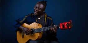 Okaidja Afroso playing guitar